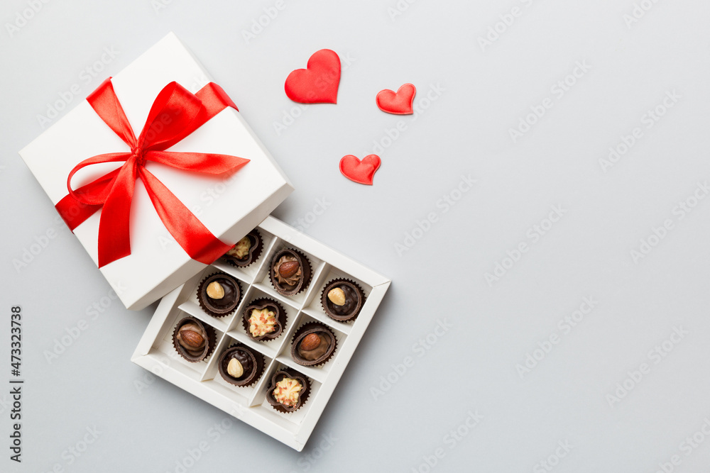 Delicious chocolate pralines in red box for Valentine's Day. Heart shaped box of chocolates top view with copy space Delicious chocolate pralines in red box for Valentine's Day. Heart shaped box of chocolates top view with copy space