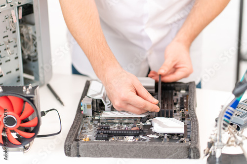 a man repairs motherboard. computer repair shop. professional services. 