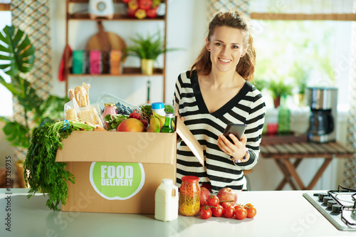 happy young female with food box in kitchen