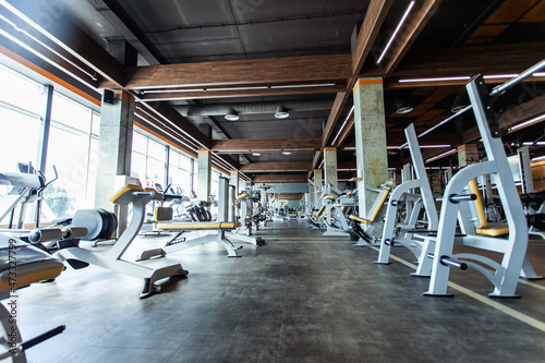 Modern gym interior with fitness equipment and exercise machines. Sports hall with large windows © splitov27