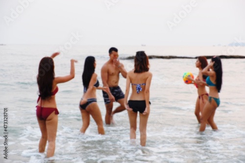 Blurred sexy bikini asian women wearing swimwear playing with friends in seaside on the beach