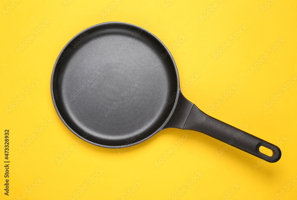 Pancake non-stick frying pan on yellow background Pancake non-stick frying pan on yellow background
