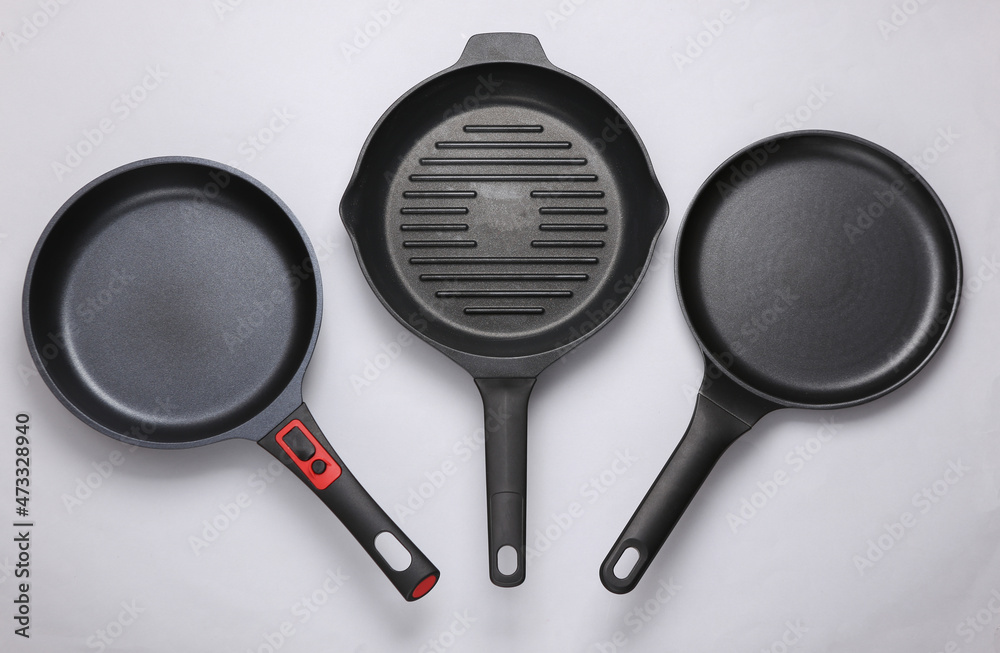 Set of Three different pans on a gray background Set of Three different pans on a gray background
