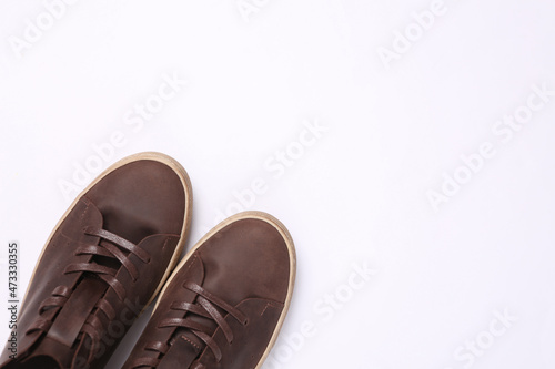 Mens brown leather sneakers on gray background. Top view. Copy space