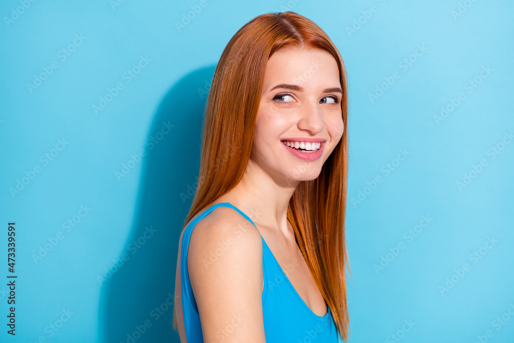 Profile side view portrait of attractive cheerful girl looking aside copy space solution isolated over vibrant blue color background