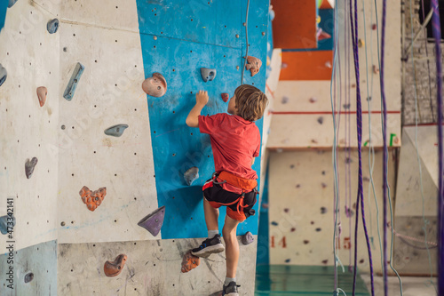 Boy at the climbing wall without a helmet, danger at the climbing wall