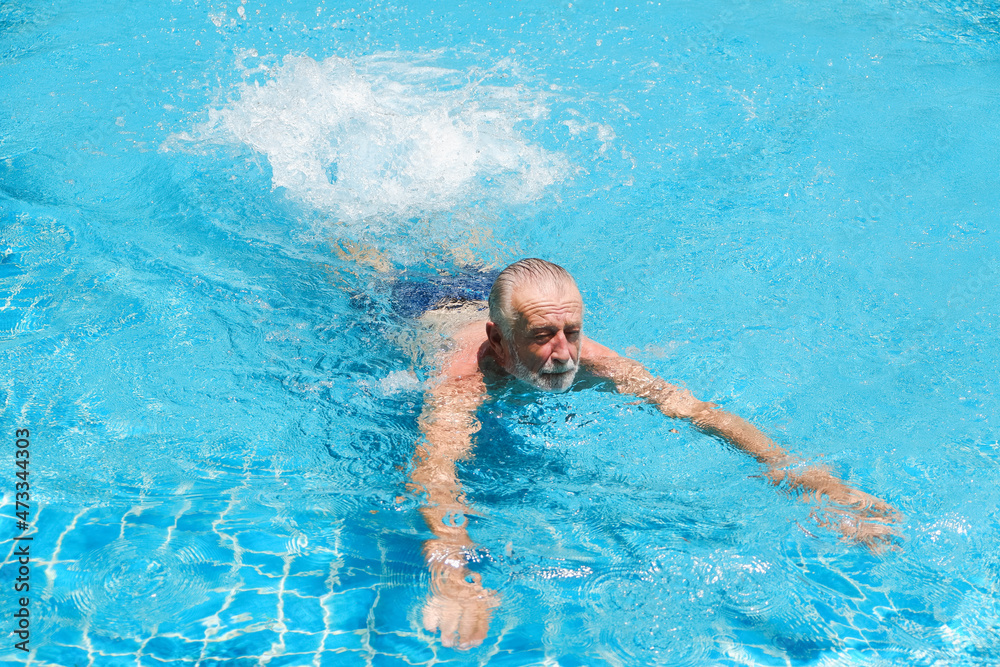 caucasian elder, senior mature man resting in swimming pool