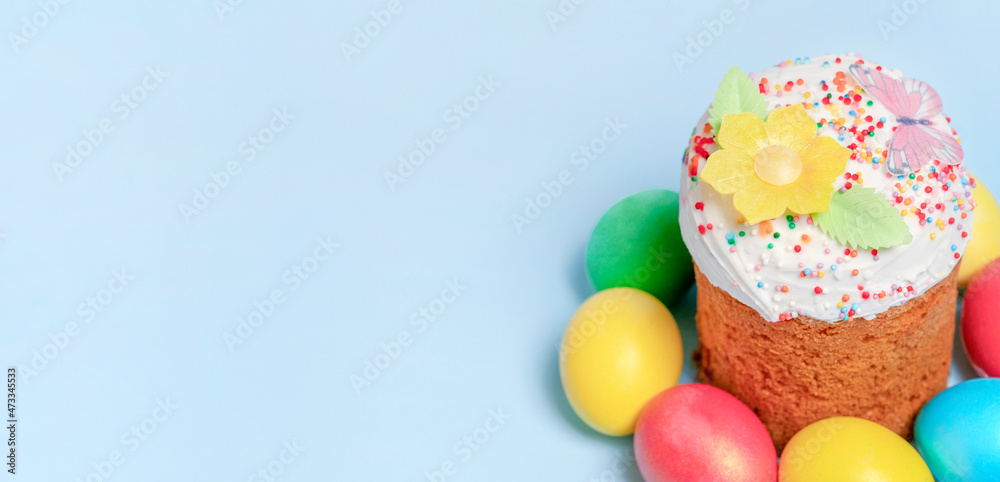 Banner. Colorful eggs with easter bread on blue background. Happy Easter. Christian traditions. Copy space for text. Banner. Colorful eggs with easter bread on blue background. Happy Easter. Christian traditions. Copy space for text.