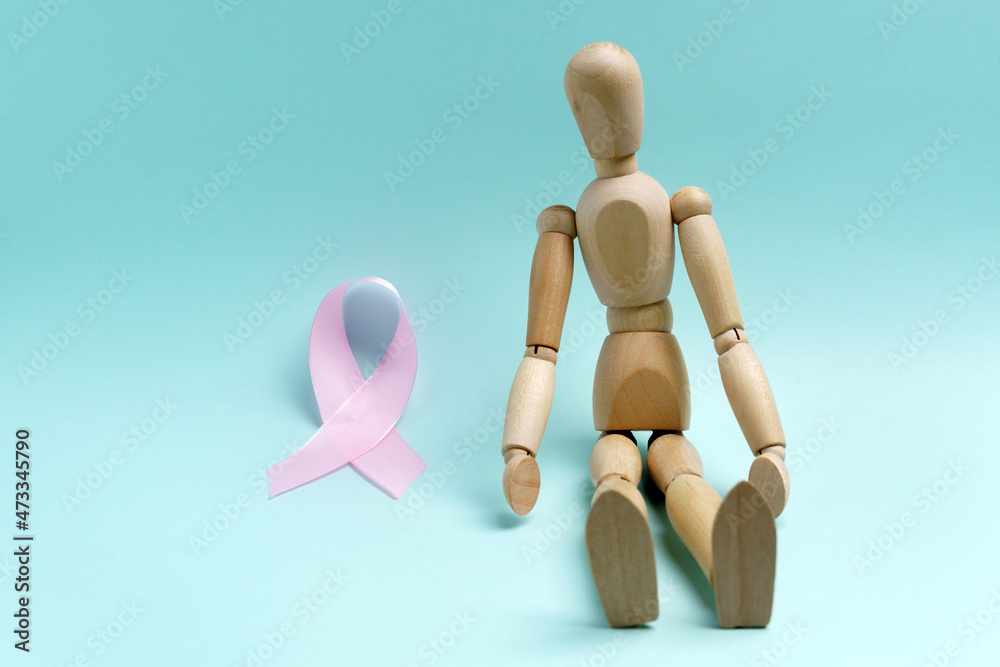 Pink ribbon and wooden mannequin. Health concept pink ribbon. Breast cancer. Pink ribbon and wooden mannequin. Health concept pink ribbon. Breast cancer.