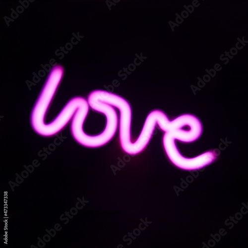 The word love in neon on dark display	