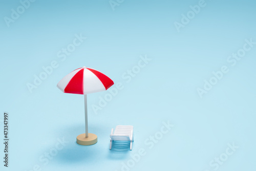 Travel concept. Sun lounger, red umbrella on a blue background.