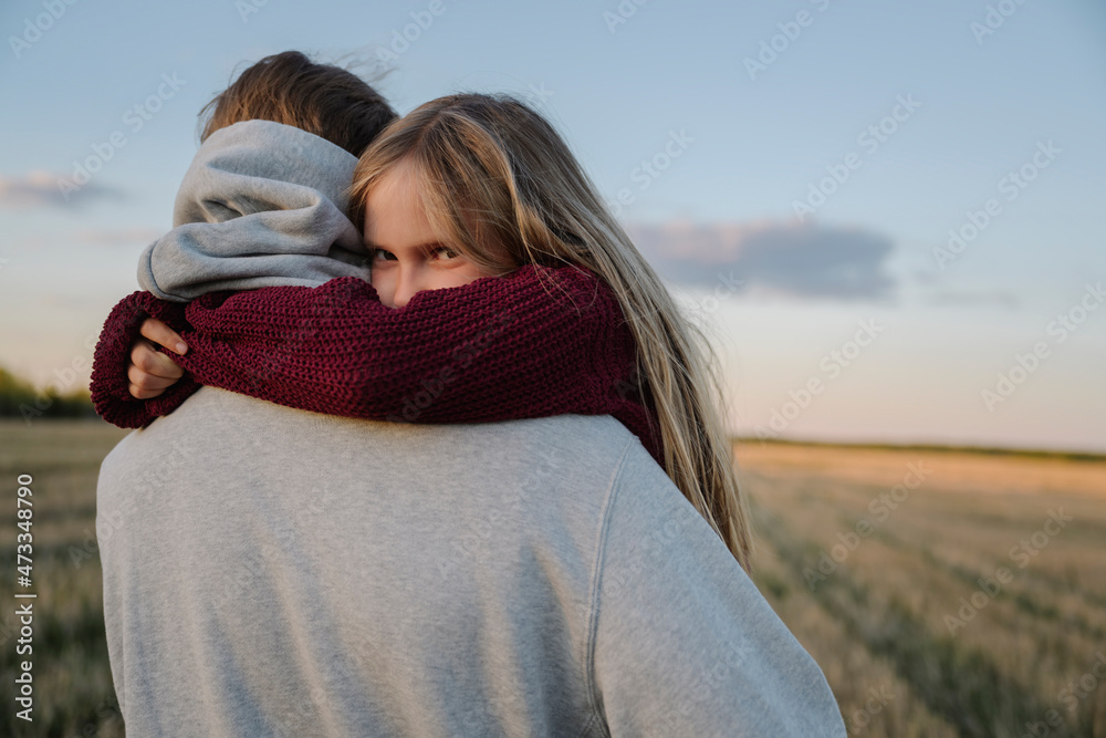 Daughter embracing father during sunset Daughter embracing father during sunset