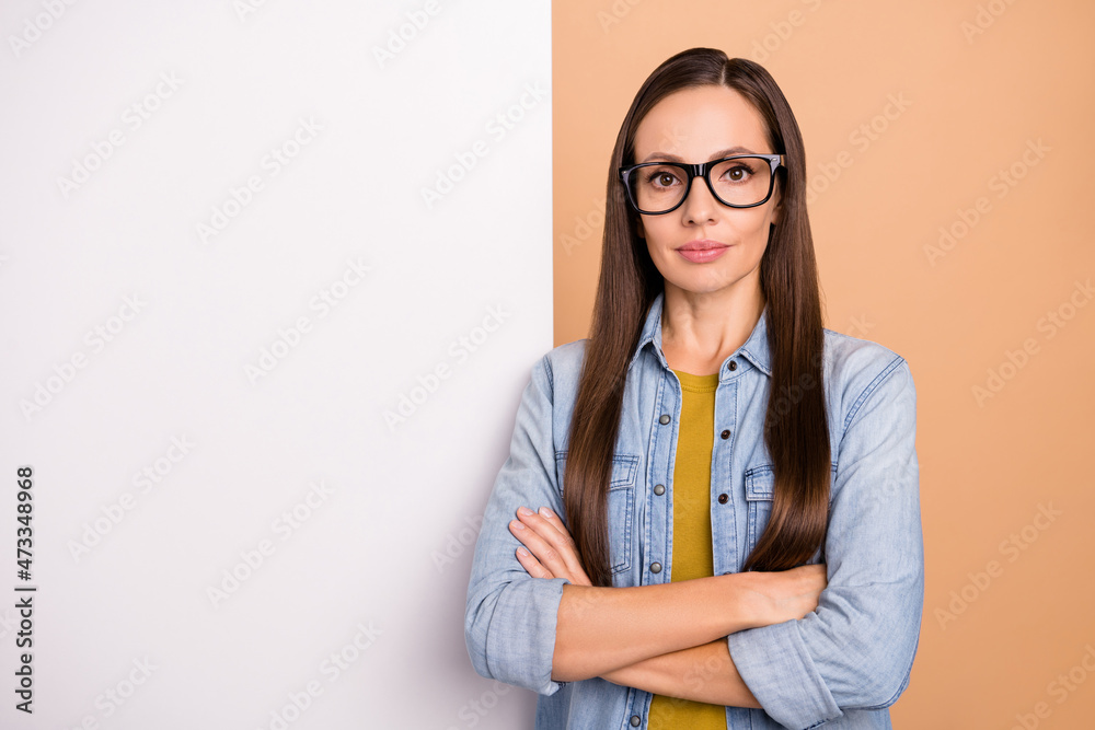 Photo of cool serious businesswoman posing with white placard advertisement isolated on beige color background Photo of cool serious businesswoman posing with white placard advertisement isolated on beige color background