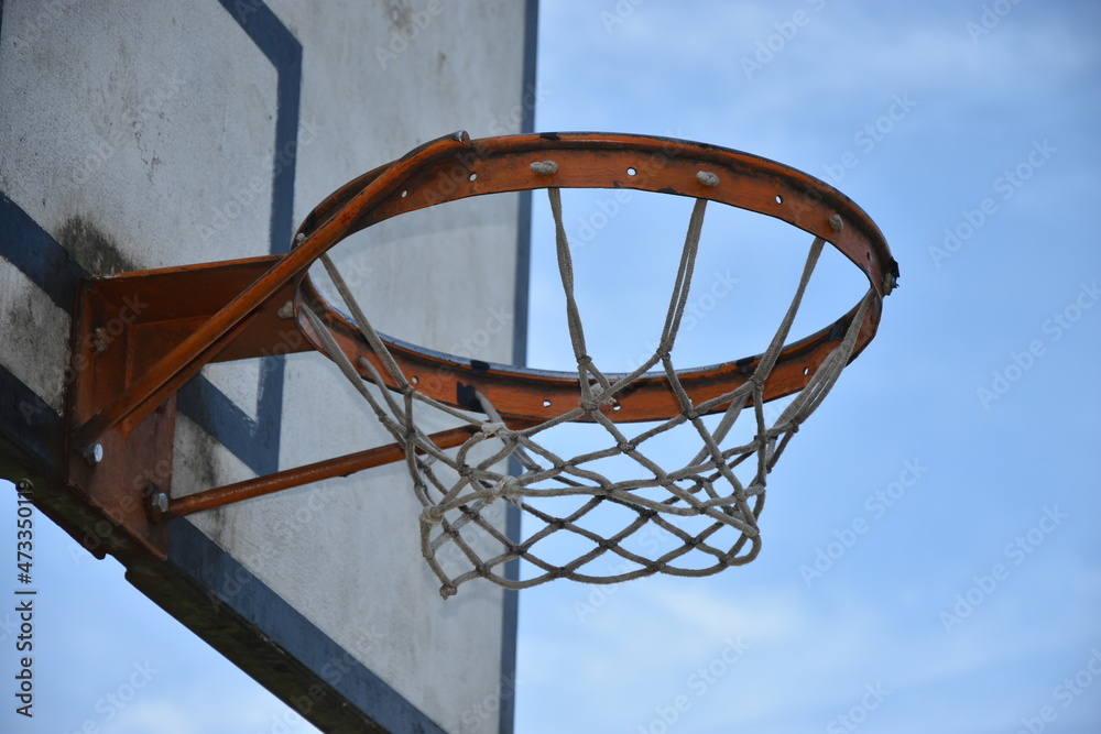 Aro de baloncesto y tablero, de parque con fondo de cielo azul, con tablero un poco sucio por el uso