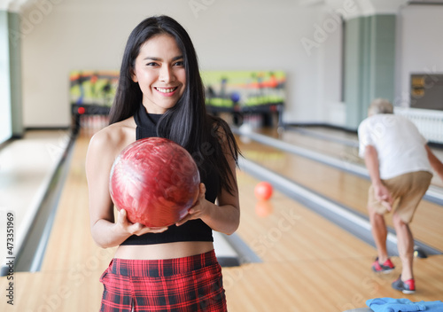 Portrait beautiful asia girl is holding a bowling ball