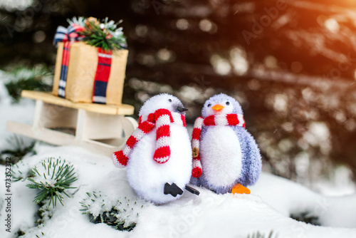 Christmas background-penguins carry a gift on a sled
