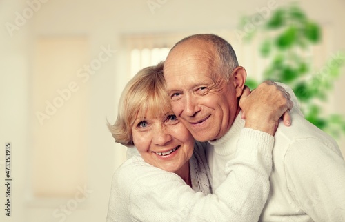 old retired age couple watching TV at home, on sofa couch at living room home