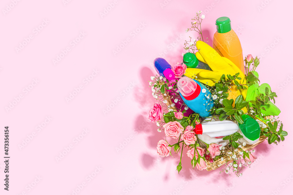 Creative bright spring cleaning concept. Tools, bottles, accessories for cleaning house with spring flowers and leaves hang on clothesline, box, bright sun light copy space