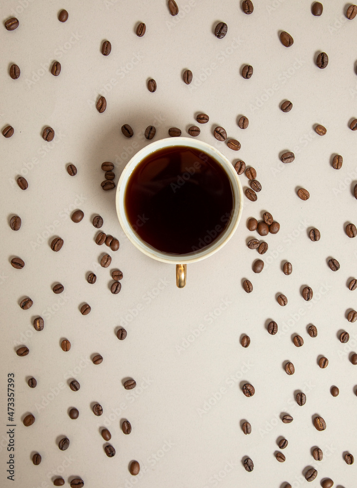 Obraz premium a cup full of coffee towards an umbrella, coffee beans falling around like rain. light brown background. 