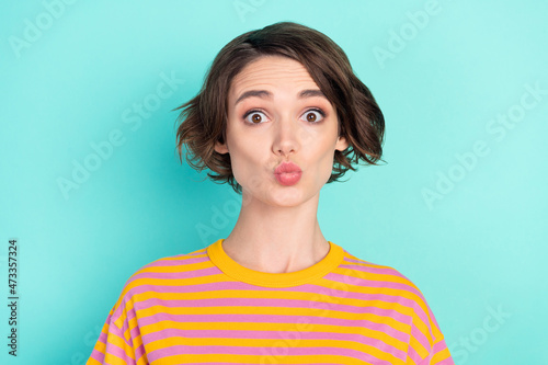 Portrait of attractive funny girlish brown-haired girl sending air kiss isolated over bright teal turquoise color background