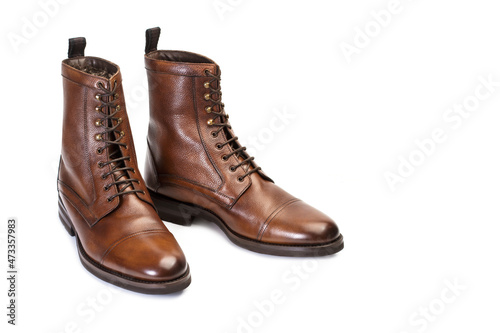 Botas zapatos de hombre de piel marrón con cordones sobre un fondo blanco liso y aislado. Vista de frente. Copy space © Mercedes Fittipaldi