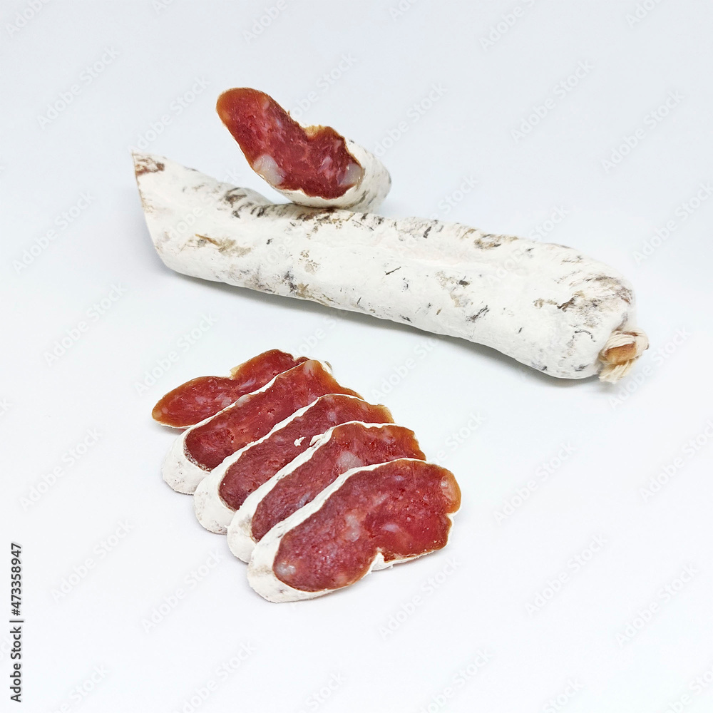 Delicious typical spanish blood sausage made with pork or beef. Sausage in white mold. Whole stick of salami sausage and chunks Delicious typical spanish blood sausage made with pork or beef. Sausage in white mold. Whole stick of salami sausage and chunks