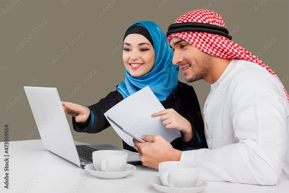 Two employees discussing in the laptop on the background Two employees discussing in the laptop on the background