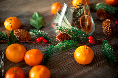 New Year's composition of tangerines and Christmas tree branches on a wooden background. Christmas background.