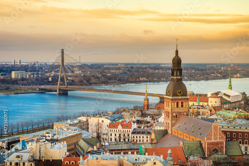 Panorama of the city of Riga on a sunny day, morning, sunset, a view of the old town, narrow streets, red brick roofs of houses, cathedrals, a river and bridge.