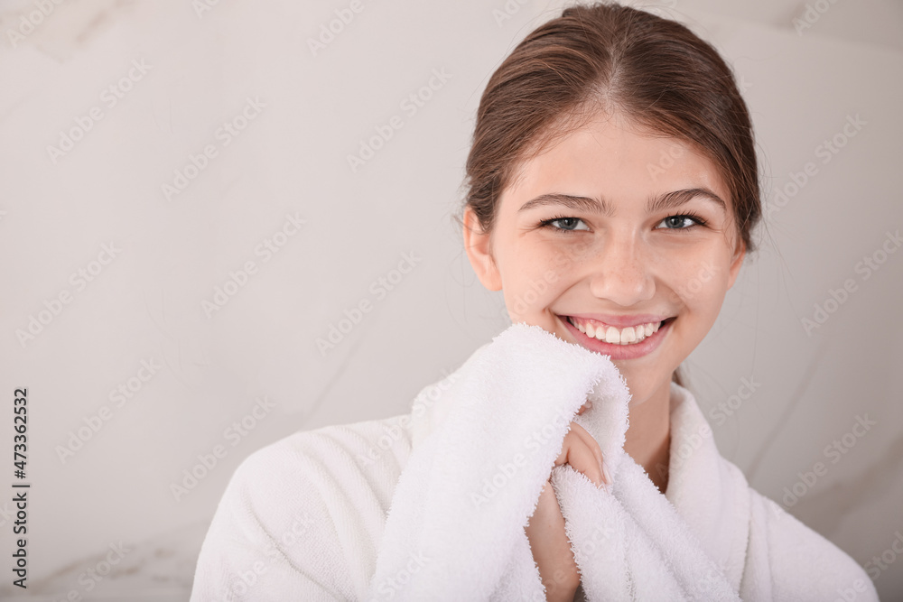 Beautiful teenage girl wiping face with towel at home, space for text Beautiful teenage girl wiping face with towel at home, space for text