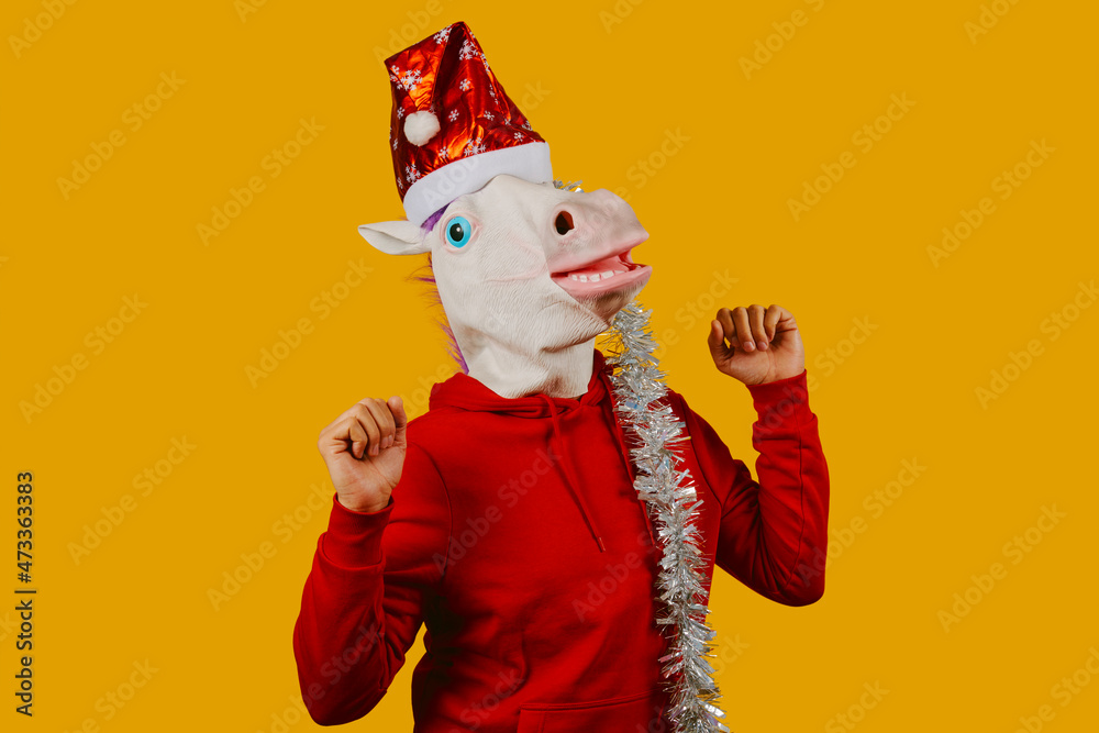 man dancing wearing a unicorn mask and a santa hat