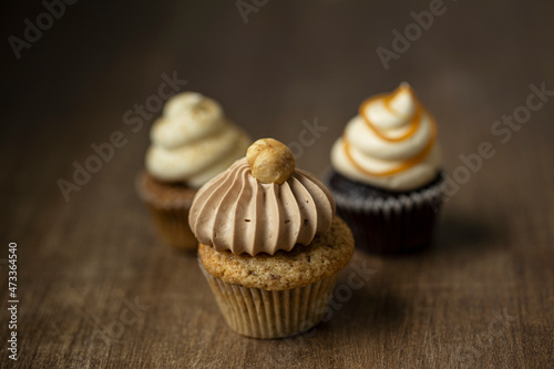 A selection of cupcakes with nuts, caramel and chai-latte cream photo