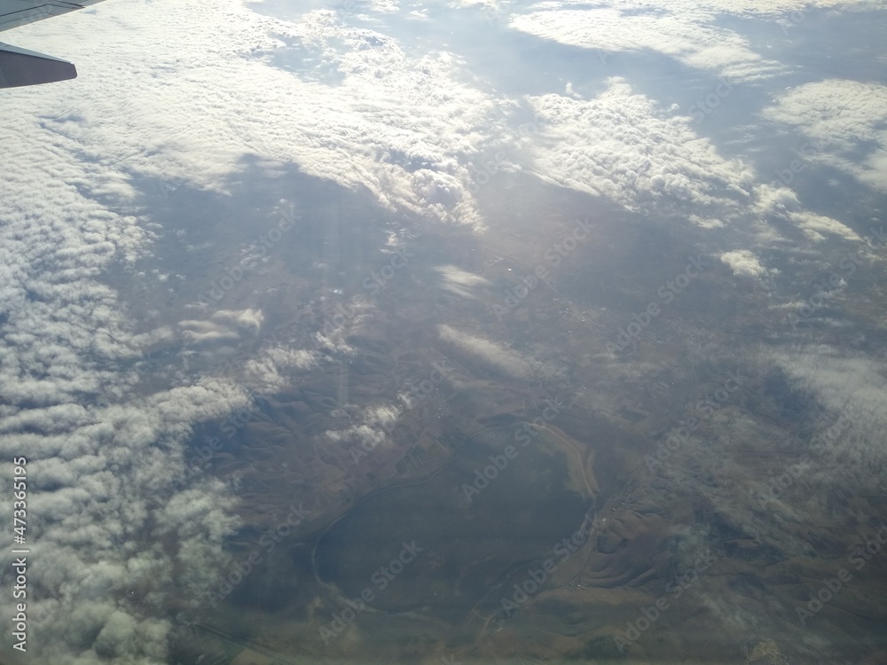 View from the window of the aircraft on the coastline and clouds. High quality photo