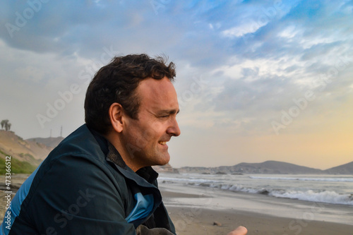 Cheerful mature Caucasian man looking at the sea.