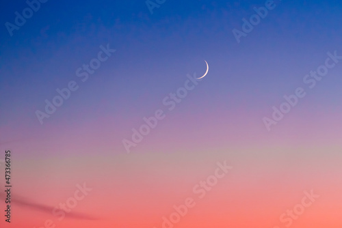 Crescent at the sunset sky. Sunset colors and new moon.