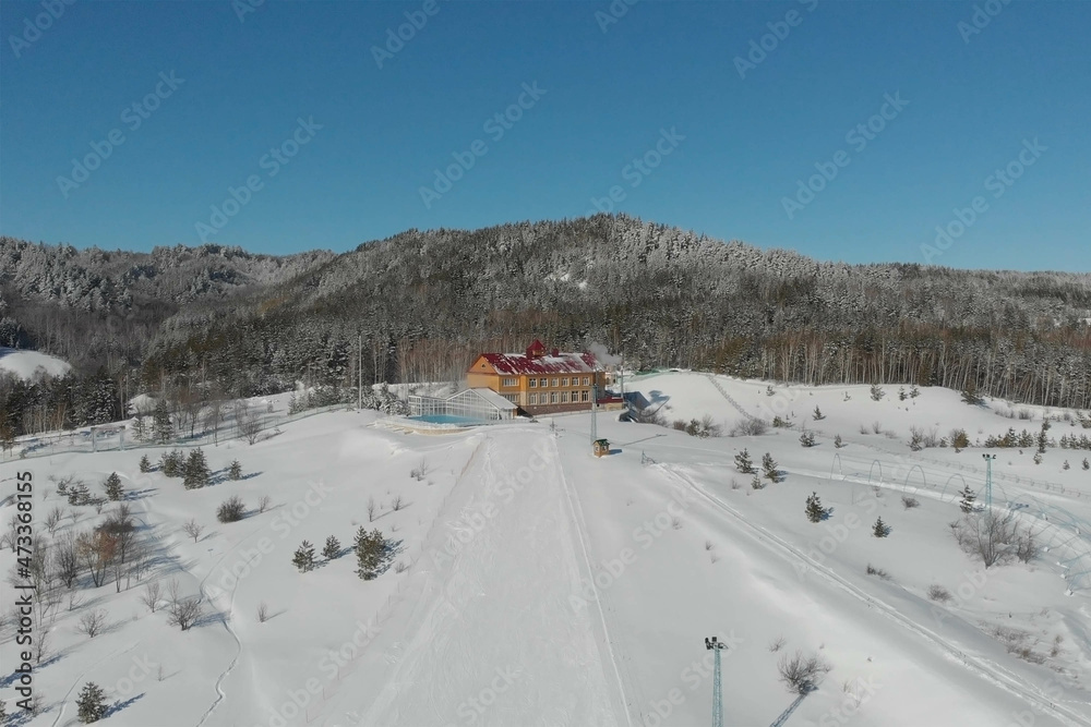 Scenic valley of hilghland alpine mountain winter resort on bright sunny day. Wintersport scene with people enjoy skiing and snowboarding on groomed pisets. panoramic wide view of downhill slopes Scenic valley of hilghland alpine mountain winter resort on bright sunny day. Wintersport scene with people enjoy skiing and snowboarding on groomed pisets. panoramic wide view of downhill slopes