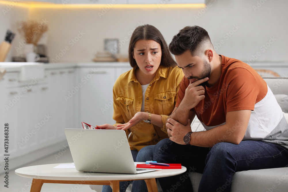 Young couple discussing family budget at home Young couple discussing family budget at home