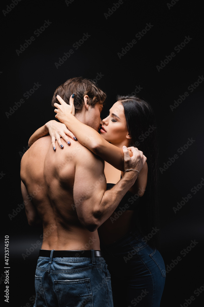 young sexy couple with closed eyes kissing while standing on black. young sexy couple with closed eyes kissing while standing on black.