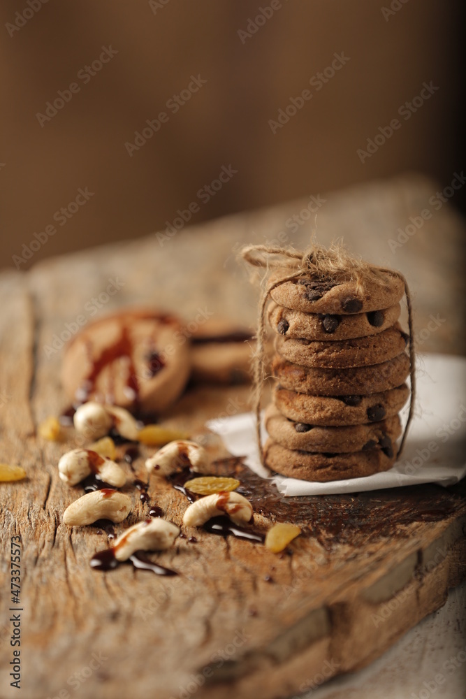 Stack of cookies tied with thread and placed on table with group of Cashew & Chocolate Stack of cookies tied with thread and placed on table with group of Cashew & Chocolate