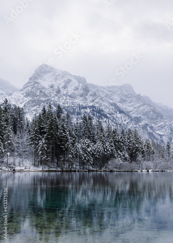 snow covered mountains in winter next to lake