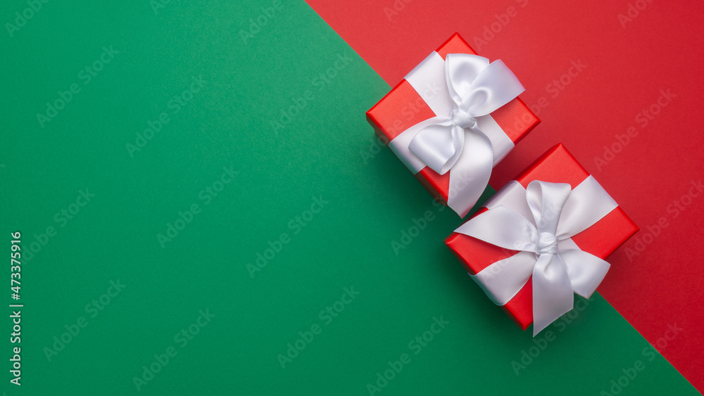 Celebratory red and green background with two gift boxes. Christmas background with copyspace. Holiday concept Celebratory red and green background with two gift boxes. Christmas background with copyspace. Holiday concept