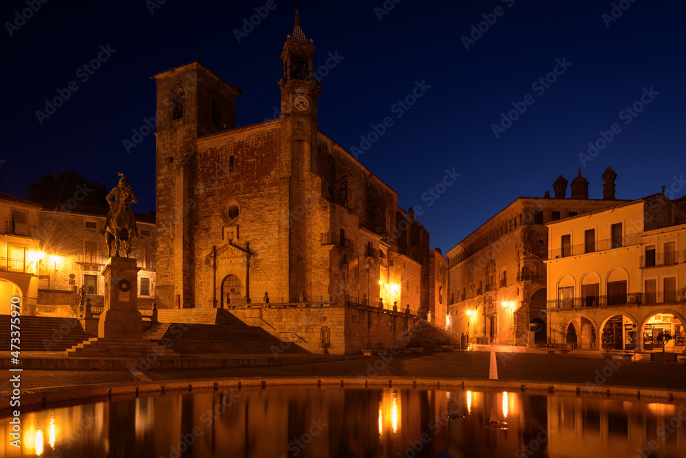 Night View of the main square of the medieval city of Trujillo with the Catholic Church of San Martin in gothic style and the equestrian statue of Francisco Pizarro at sunrise, Caceres, Extremadura, S