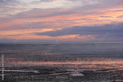 Canvastavla Tranquil coastal landscape with a calm sea meeting a pebble beach beneath a soft pastel sunset sky