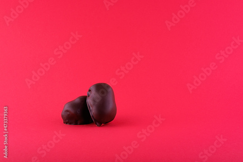 Two chocolates on a red background close-up photo
