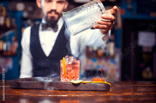 Portrait of barman is pouring a drink at bar photo