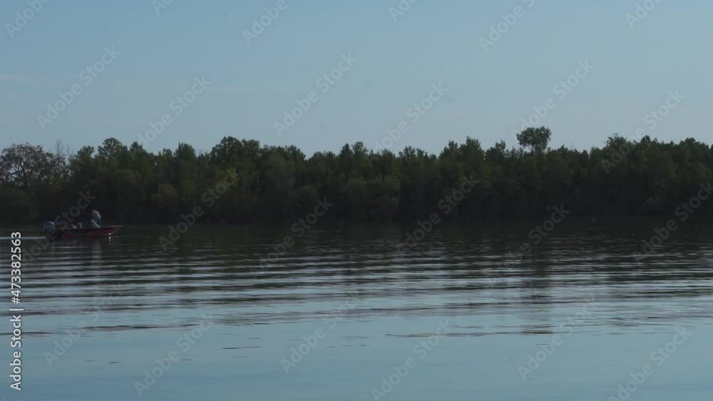 Fishing in the lake; a small rowboat comes into view on quiet, calm clear early morning lake water; grey blue early morning with clear skies. Northern Michigan. 401 Fishing in the lake; a small rowboat comes into view on quiet, calm clear early morning lake water; grey blue early morning with clear skies. Northern Michigan. 401