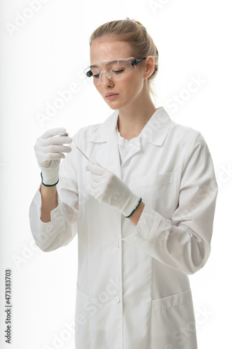 The girl laboratory assistant shows an indicator tube with the result of the analysis. Laboratory assistant in a medical laboratory or a petroleum product quality laboratory