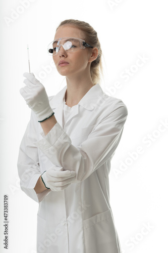 The girl laboratory assistant shows an indicator tube with the result of the analysis. Laboratory assistant in a medical laboratory or a petroleum product quality laboratory