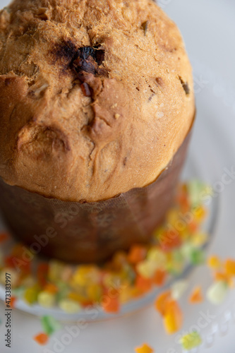 Photography Panettone on the table, in the background colored candied fruits, approximate ph