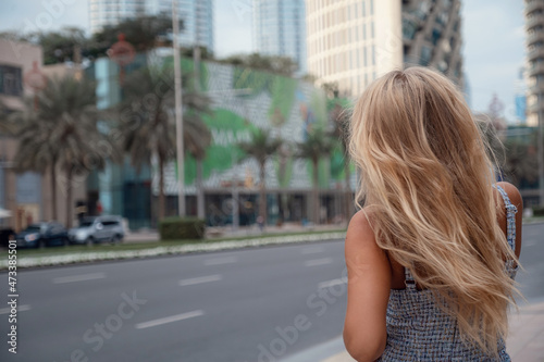 Young beautiful blonde woman walk in Dubai downtown. Enjoying travel in United Arabian Emirates. Vacation and sightseeing concept